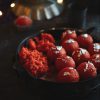red strawberries on black ceramic bowl